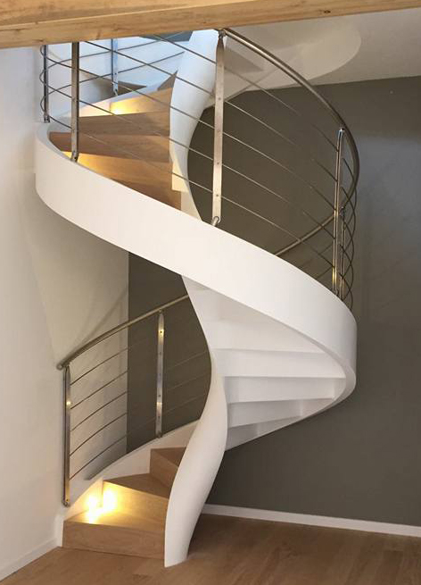 Escalera helicoidal con peldaños de madera y focos realizada en Modena