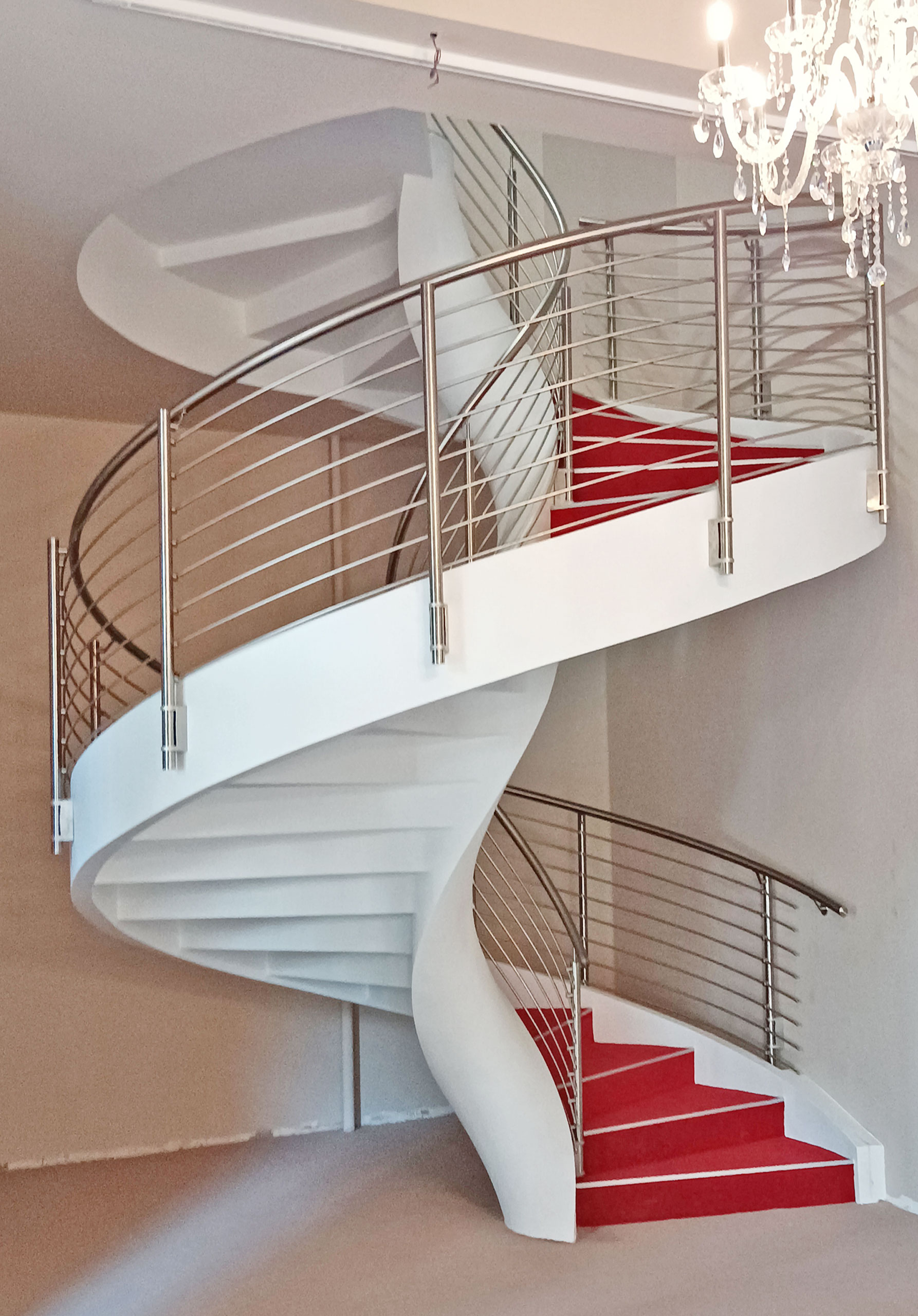 Escalera helicoidal con peldaños cubiertos con alfombra roja construida en una escuela de Verona, Italia